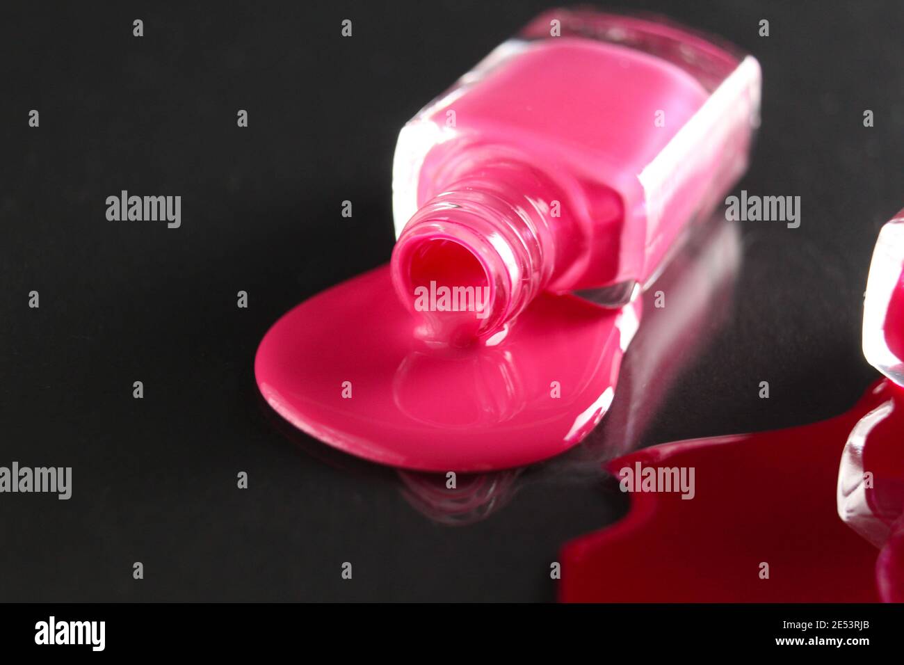 Beauty Hintergrund zwei Flaschen Nagellack-Flaschen rot oder burgunderrot pink Spill gegossen auf dem Tisch auf einem schwarzen Hintergrund mit einem Copyspace . Stockfoto