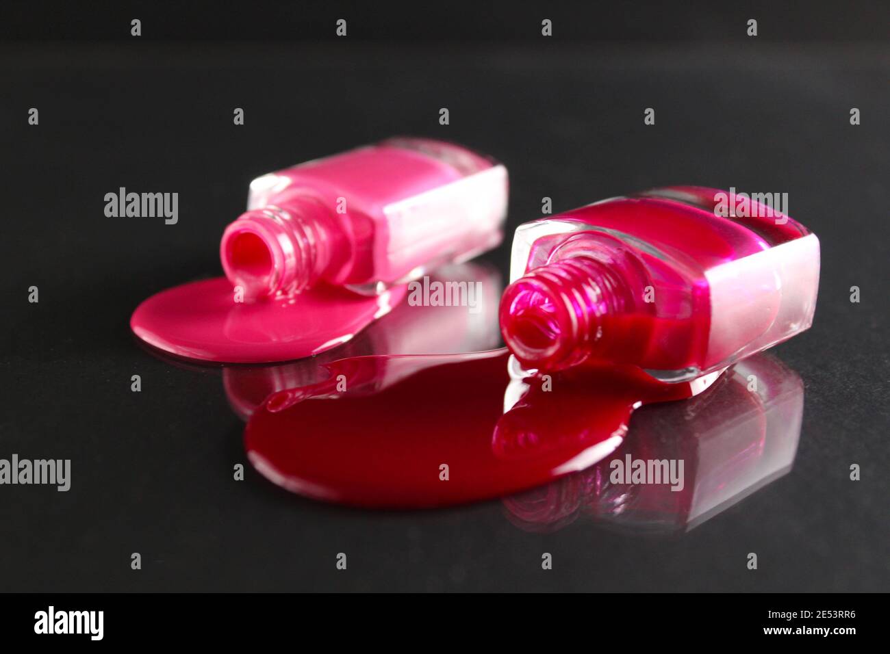 Beauty Hintergrund zwei Flaschen Nagellack-Flaschen rot oder burgunderrot pink Spill gegossen auf dem Tisch auf einem schwarzen Hintergrund mit einem Copyspace . Stockfoto