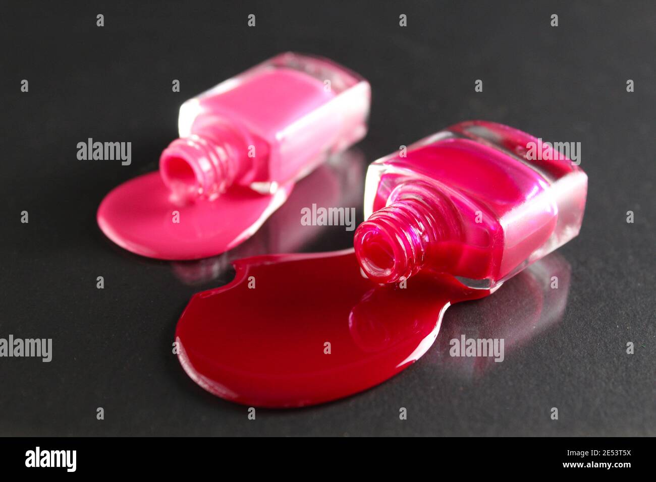 Beauty Hintergrund zwei Flaschen Nagellack-Flaschen rot oder burgunderrot pink Spill gegossen auf dem Tisch auf einem schwarzen Hintergrund mit einem Copyspace . Stockfoto