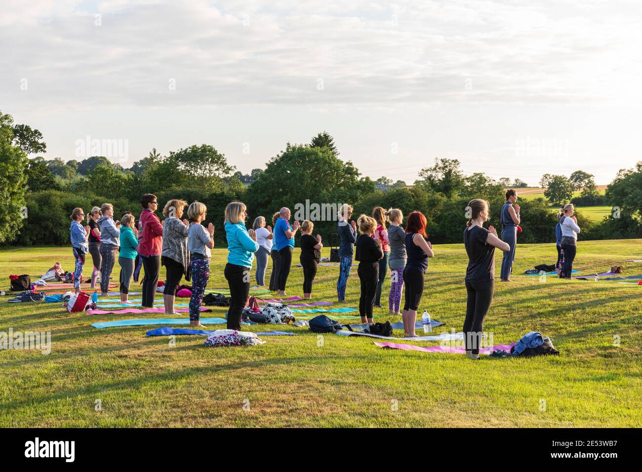 Yoga-Kurs im Freien bei Sonnenuntergang in natürlicher Umgebung Stockfoto