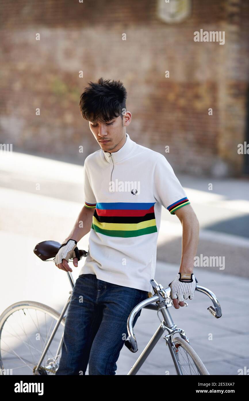 Hübscher kaukasischer Mann, der neben einem Vintage-Fahrrad steht und Cycling World trägt Championship-Farben Stockfoto