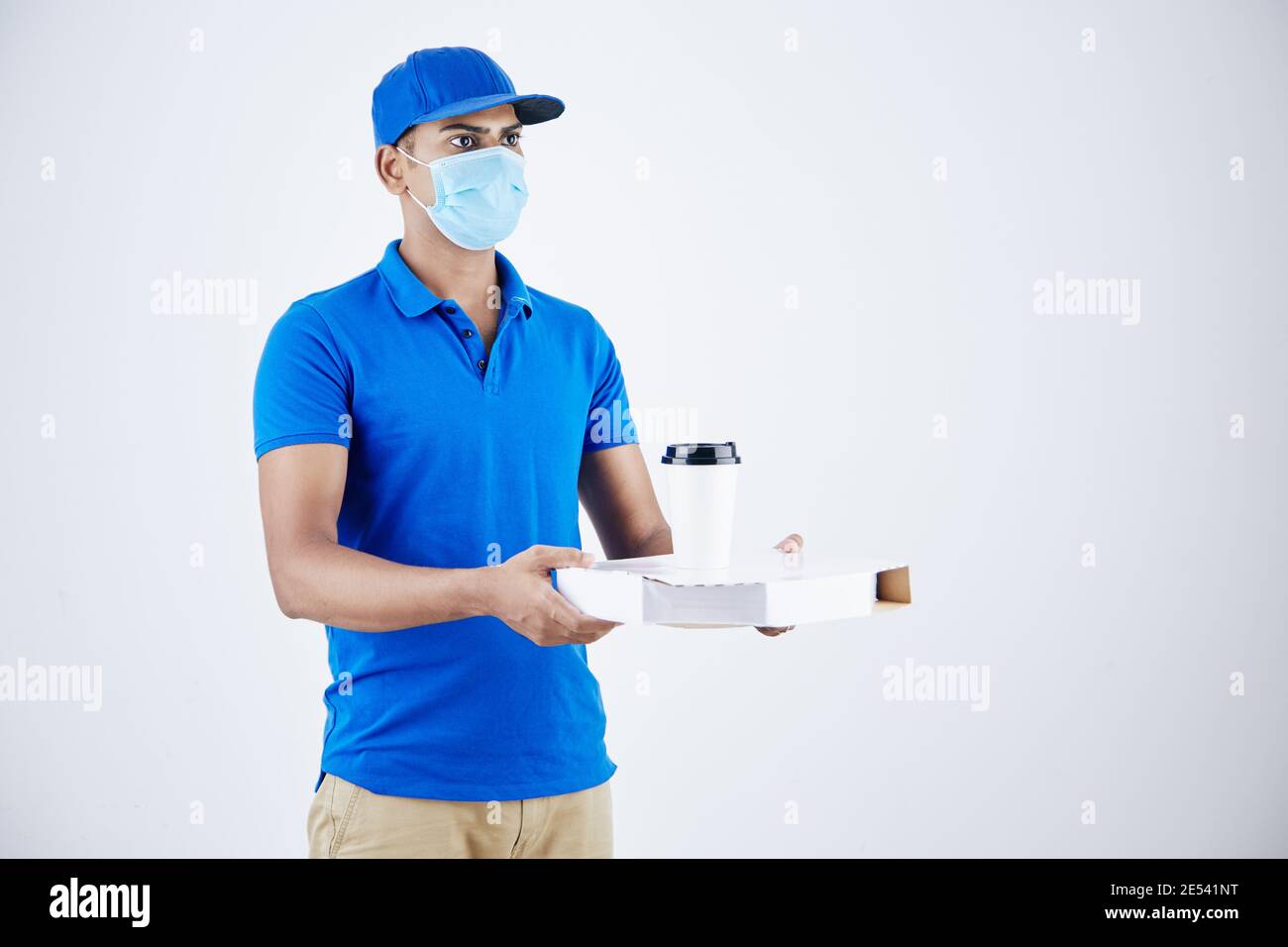 Junge seriöse indische Kurier gibt Pizza-Box und nehmen Sie Kaffee, isoliert auf weiß Stockfoto