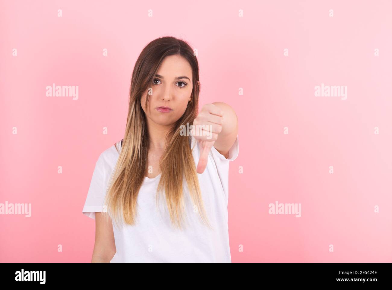 Junge Frau zeigt ihren Daumen nach unten. Geste der Missbilligung Stockfoto