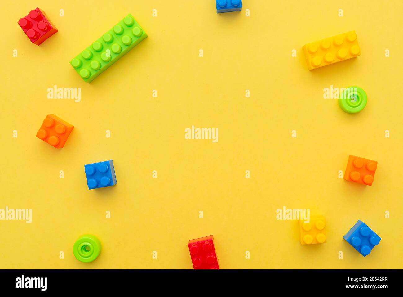 Kleine Blöcke aus Kunststoff Konstruktor auf gelbem Hintergrund, flach liegend, Draufsicht, Platz für Text Stockfoto