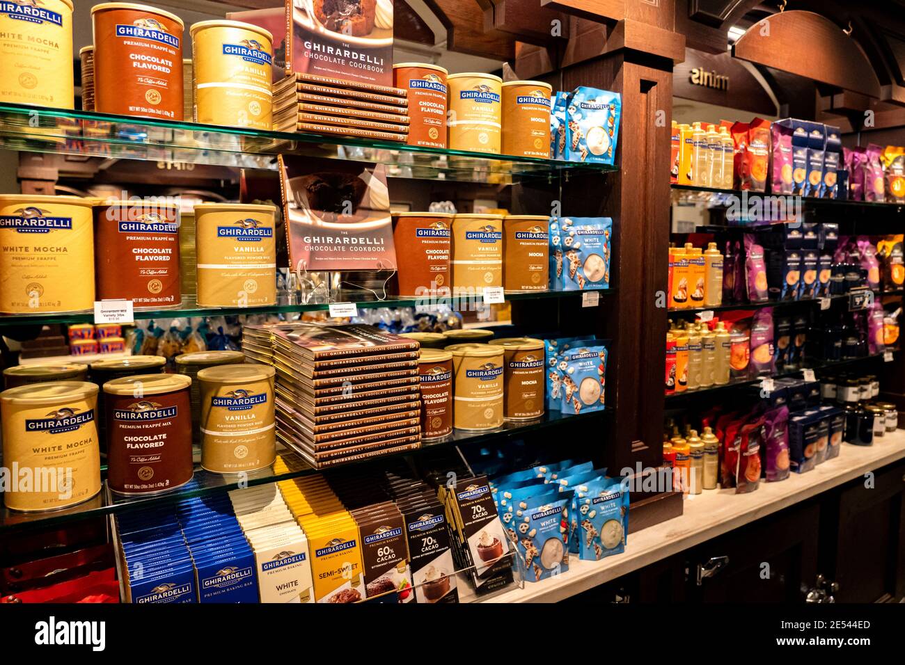 Ein Regal mit Schokolade, Rezeptheften, Frappemischung und anderen Waren im Ghirardelli Chocolate Shop. Stockfoto