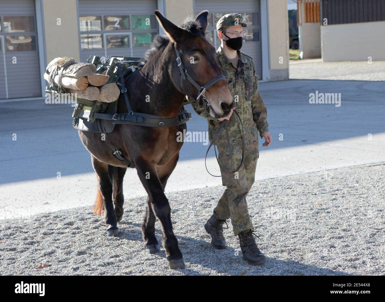 Berchtesgaden, Deutschland. Januar 2000. Ein Soldat des Bergjägerbataillons geht mit einem Maultier über den Kasernenplatz. Die 36 Maultiere und 18 Haflinger in Bad Reichenhall werden von 142 Betreuern betreut und zwei Tierärzte kümmern sich um ihre Gesundheit. Das Betriebs- und Ausbildungszentrum dort ist der einzige Pferdedienst der Bundeswehr in Deutschland. Quelle: Kilian Pfeiffer/dpa/Alamy Live News Stockfoto