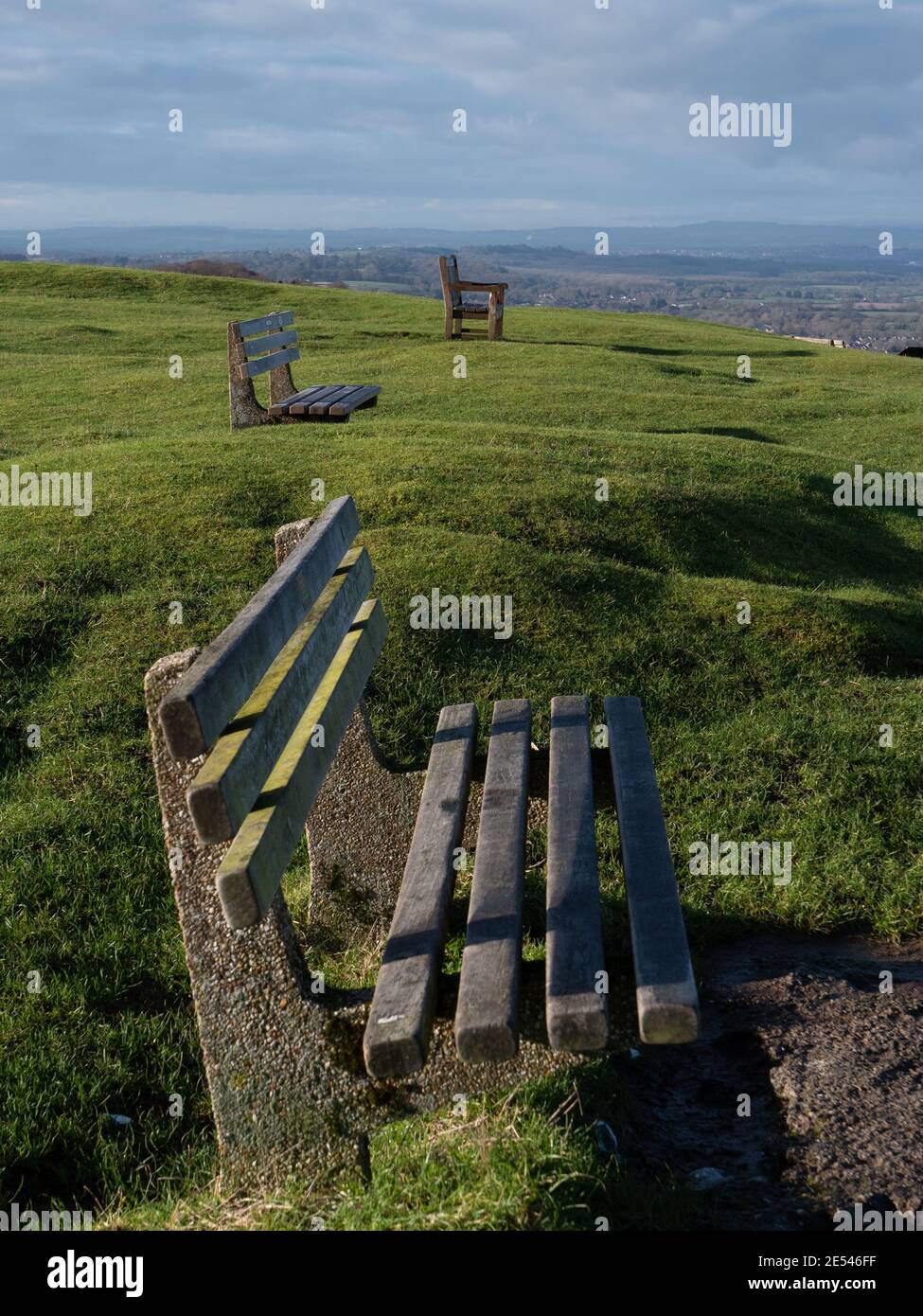 Eine Reihe von Bänken soziale Distanzierung auf dem Weißen Pferd mit Blick auf Westbury, Wiltshire, England, Großbritannien. Stockfoto