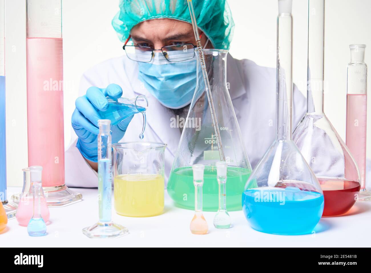Laborwissenschaftler Techniker trägt Handschuhe, Gesichtsmaske und Laborkittel konzentriert während der Forschung und Durchführung von Experimenten im Labor Stockfoto