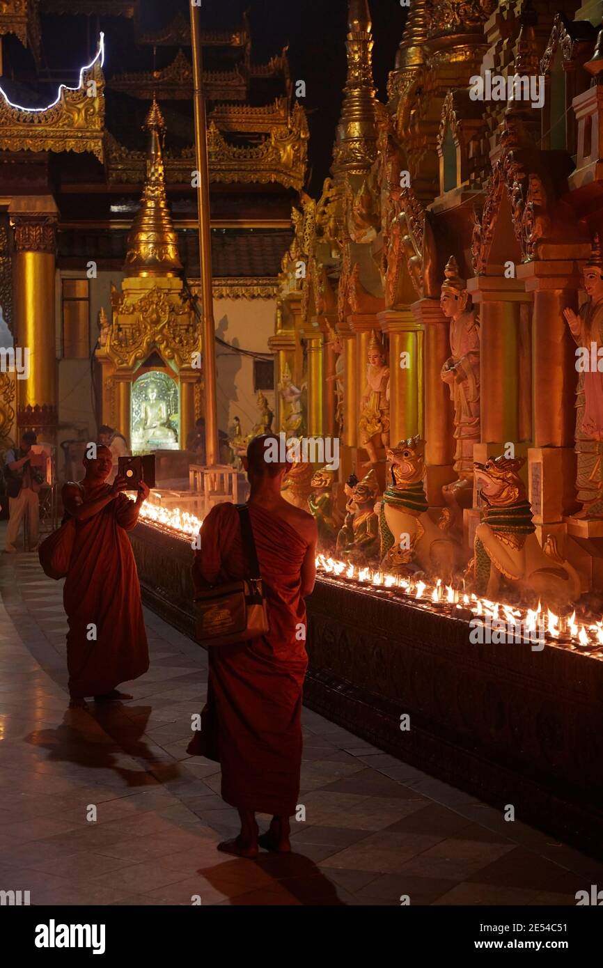 Zwei buddhistische Mönche, die ein Foto mit einer Tafel an der Shwedagon Pagode, Yangon, Myanmar, machen. Stockfoto