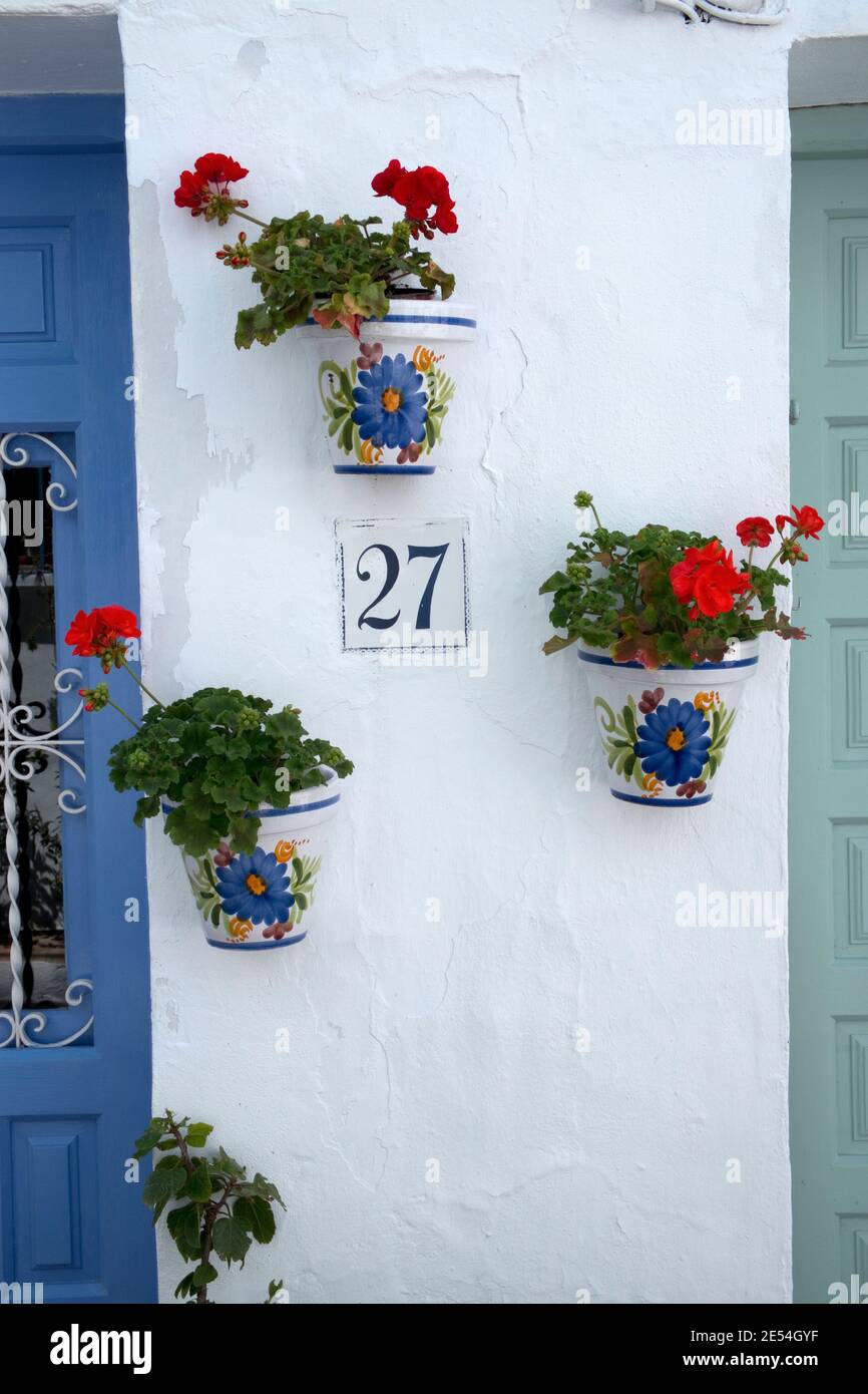 Dekorative Geranienblumen in Töpfen an den Wänden in der "weißen" Stadt Frigiliana, Spanien, England Stockfoto