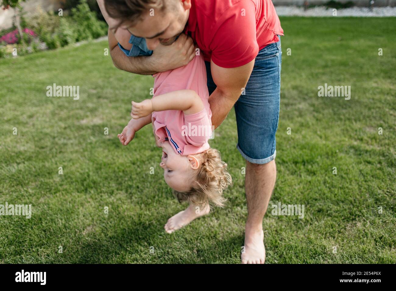 Vater spielt mit seinem Sohn draußen im Garten. Glückliches Kind, das Spaß mit seinem Vater hat. Stockfoto