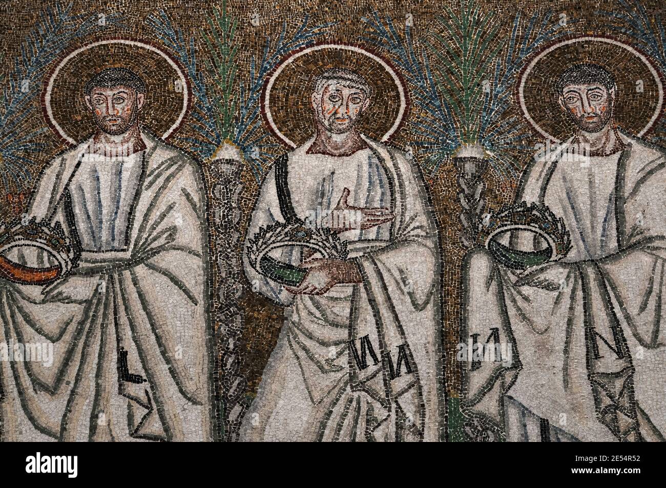 Drei von 26 männlichen christlichen Märtyrern gehen in einer Prozession. Detail aus dem byzantinischen Mosaik in der Basilica di Sant’Apollinare Nuovo in Ravenna, Emilia-Romagna, Italien. Das Mosaik entstand in den 500er Jahren n. Chr., wenige Jahre nachdem Ravenna von den Ostgoten erobert wurde. Stockfoto