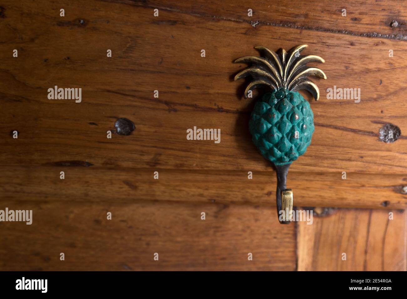 Nahaufnahme auf grün und Gold ananas-förmigen Kupfer-Kleiderbügel auf Holz Stockfoto