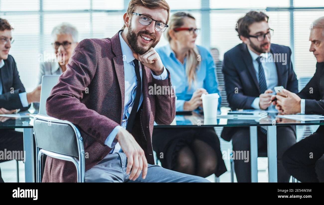 Lächelnder Geschäftsmann sitzt an einem Büroschalter. Stockfoto