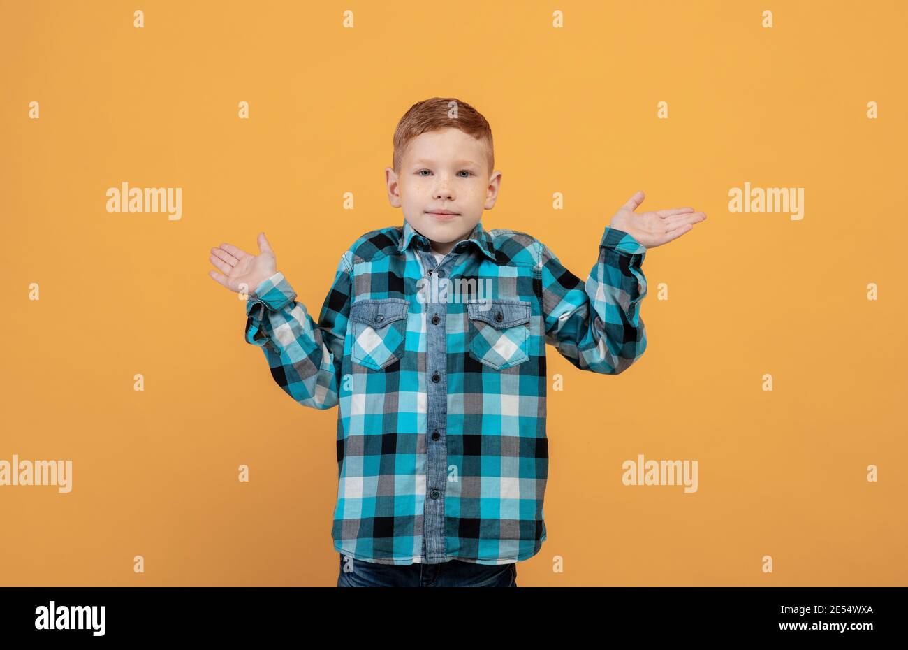 Verwirrt Schuljunge zeigt Verwirrung, gelber Hintergrund Stockfoto