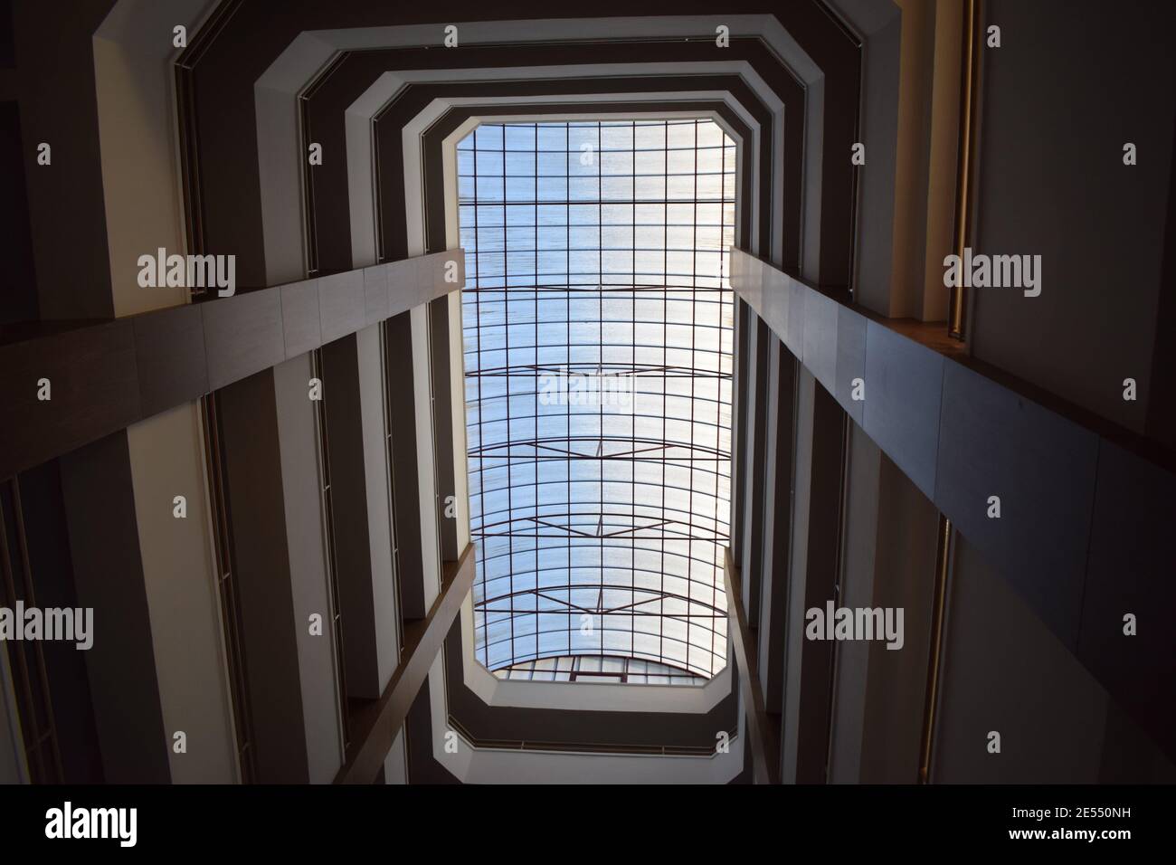 Blick von unten auf die Hotelhalle Treppe und schöne geometrische Decke. Designelement. Abstrakte Geometrie Perspektive innerhalb eines Gebäudes für den Hintergrund Stockfoto