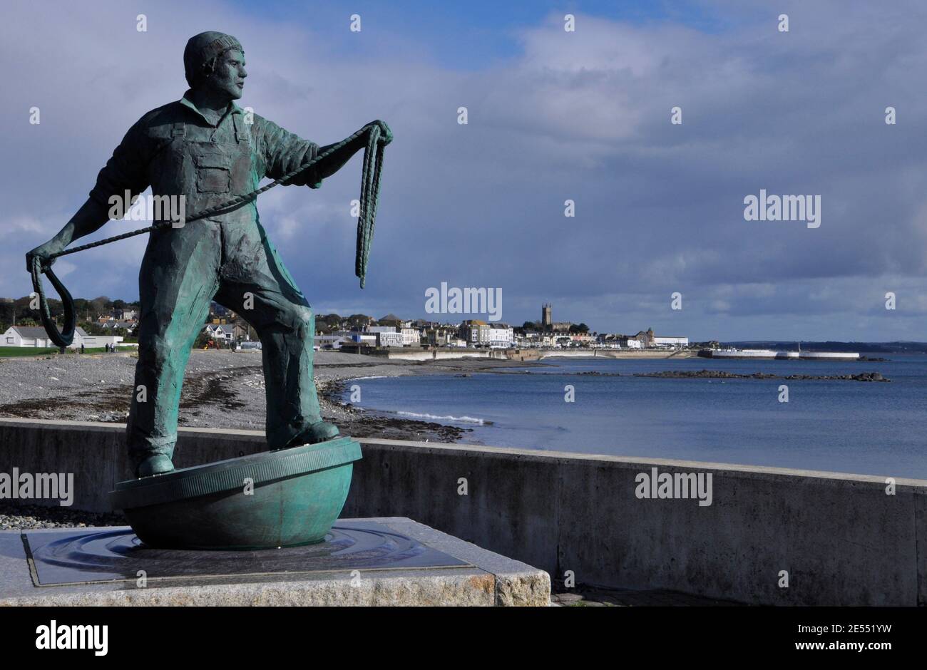 Die lebensgroße Bronzestatue eines Fischers mit Blick auf das Meer bei Newlyn in Cornwall. Errichtet in Erinnerung an alle kornischen Fischer, die los gewesen sind Stockfoto