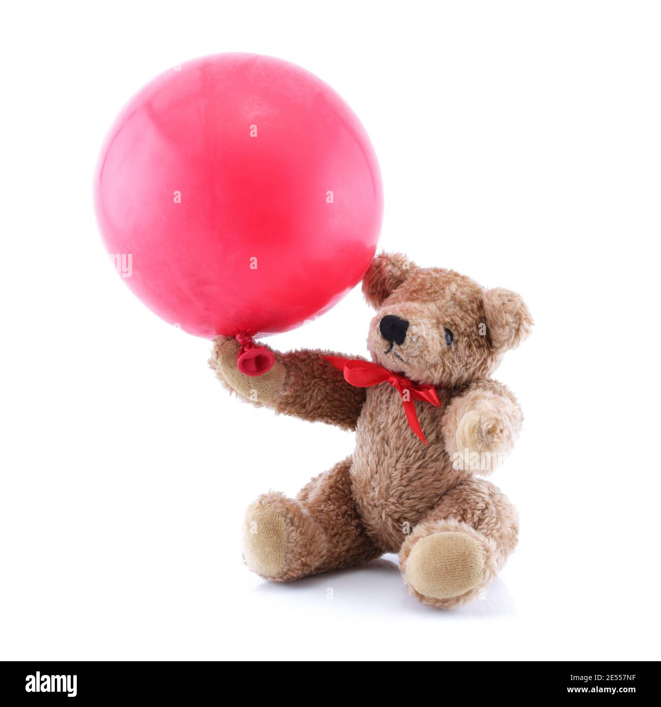 Kleiner brauner Teddybär spielt mit rotem Ballon Stockfoto