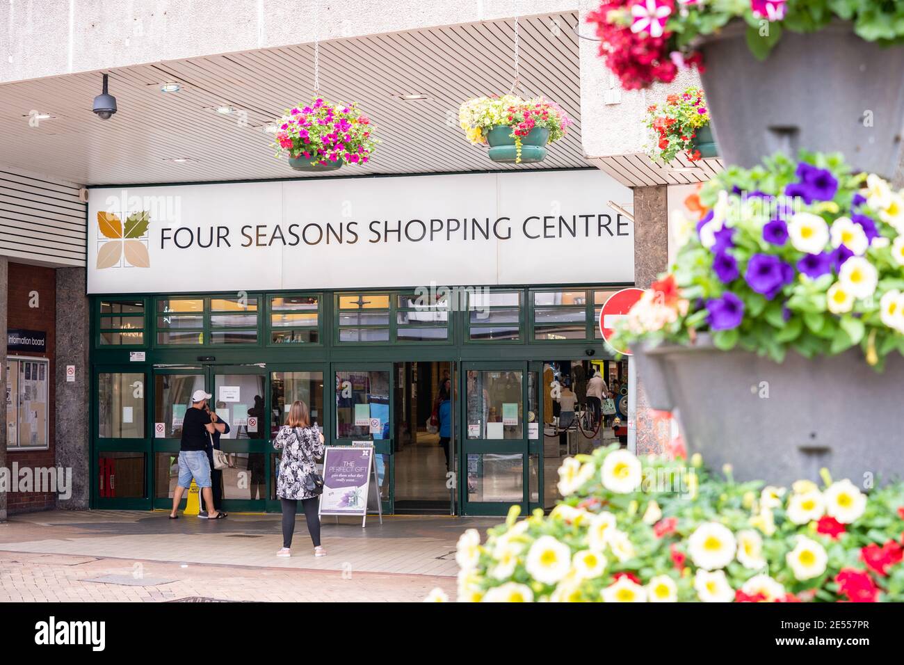 High Street Shopping mit Käufern und Geschäften geöffnet vor Pandemie Lockdown und Einzelhandelsschließungen. Four Seasons Center Blick Kunden in den Geschäften Stockfoto