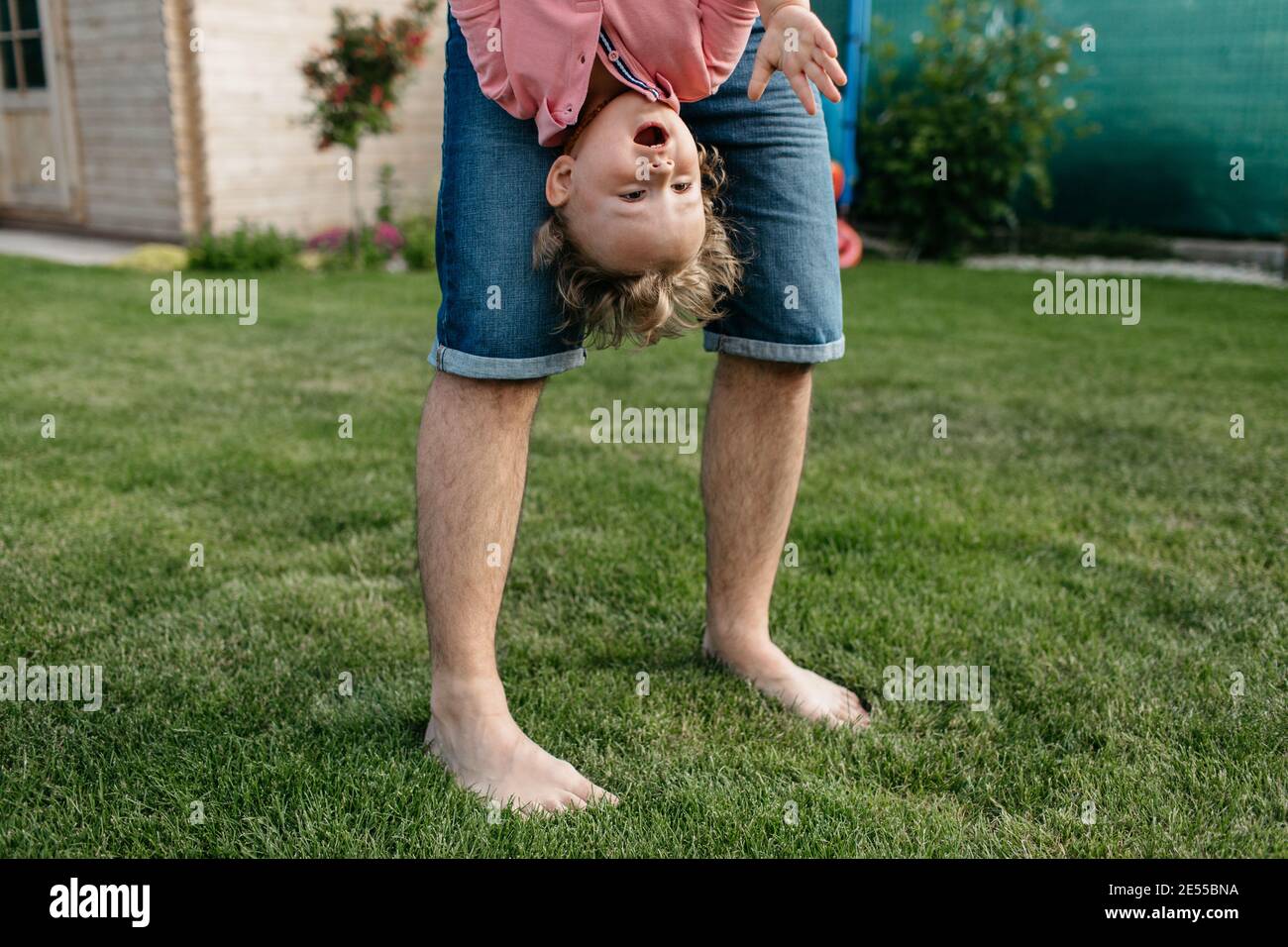 Vater spielt mit seinem Sohn draußen im Garten. Glückliches Kind, das Spaß mit seinem Vater hat. Stockfoto