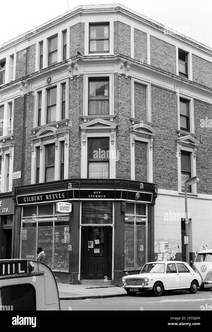 Großbritannien, West London, Notting Hill, 1973. Heruntergekommene und heruntergekommene, große, vierstöckige Häuser werden langsam restauriert und neu dekoriert. Ein Geschäft mit Lizenz an der Ecke Talbot Road (links) und Powis Square (rechts). Stockfoto
