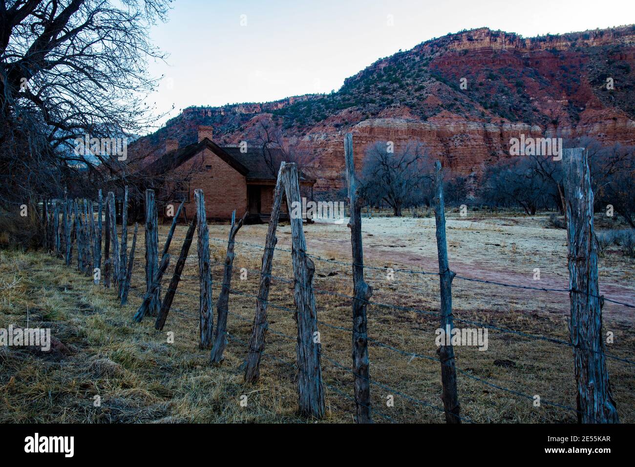 Altes Pionierhaus schmiegt sich unter dem roten Felsen mesa im Süden von Utah, USA. Dieses Pionierheim bleibt in der Geisterstadt Grafton, Utah, USA. Stockfoto