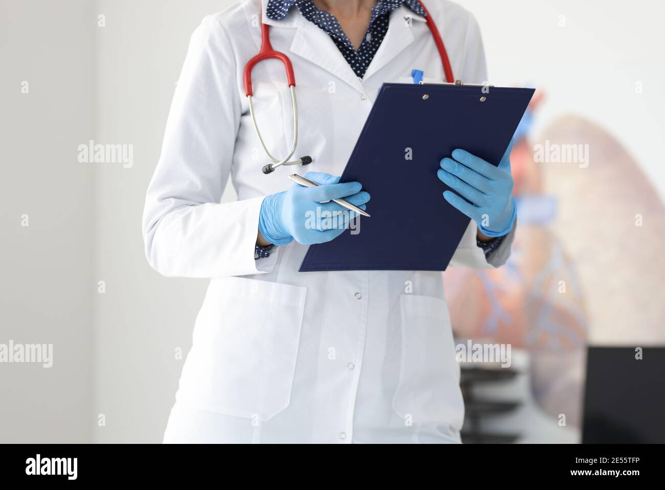 Hände des Arztes in Schutzhandschuhen halten Klemmbrett und Stift Stockfoto Hände des Arztes in Schutzhandschuhen halten Klemmbrett und Stift Stockfoto