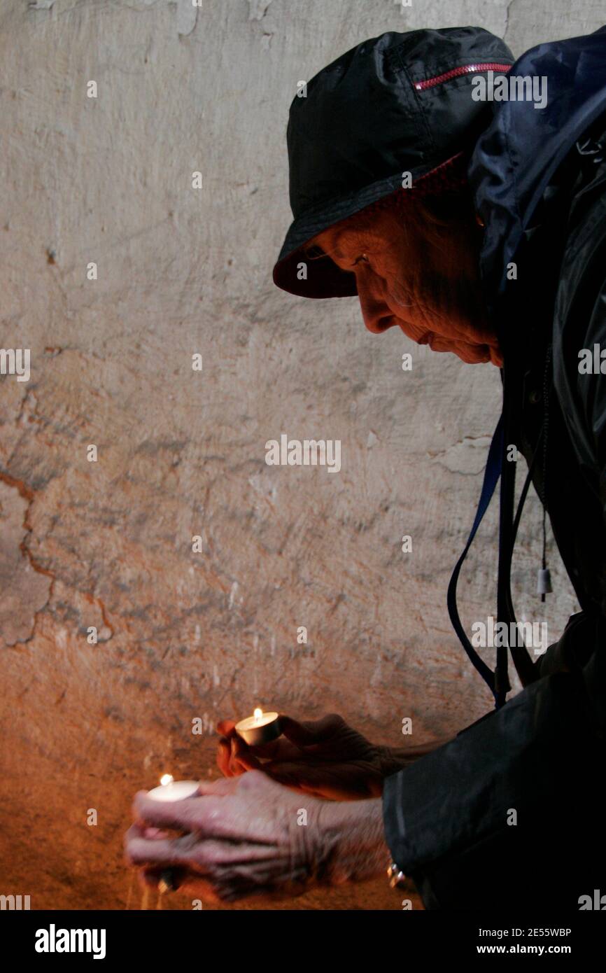 Oswiecim, Polen - 5. Mai 2005: März des Lebens in Oswiecim, im Staatlichen Museum Auschwitz-Birkenau. Eine ältere Frau zündet Kerzen in der Nähe der BA an Stockfoto