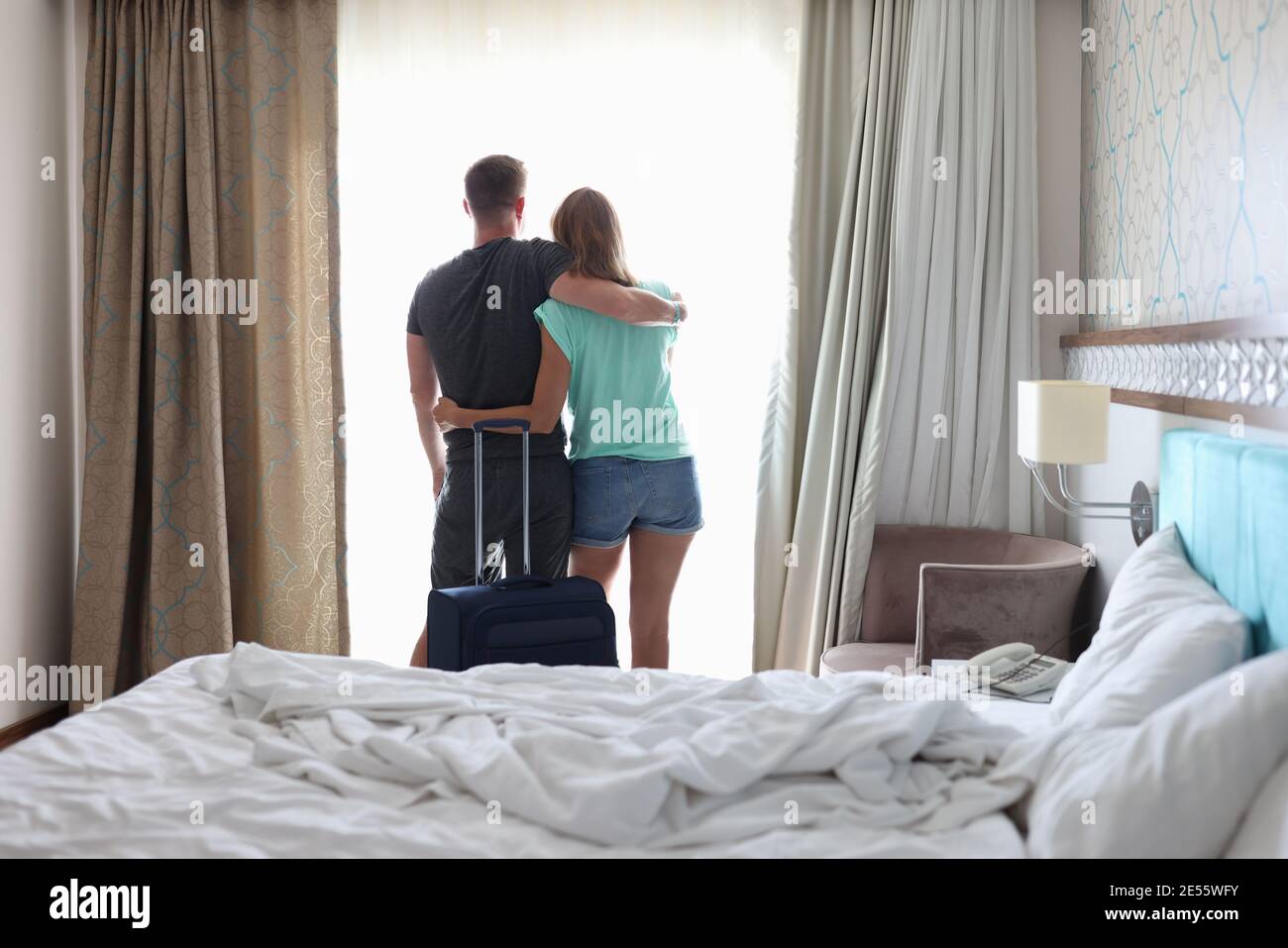 Mann und Frau umarmen sich neben dem Koffer neben dem Fenster. Wo man auf romantische Reise-Konzept gehen Stockfoto