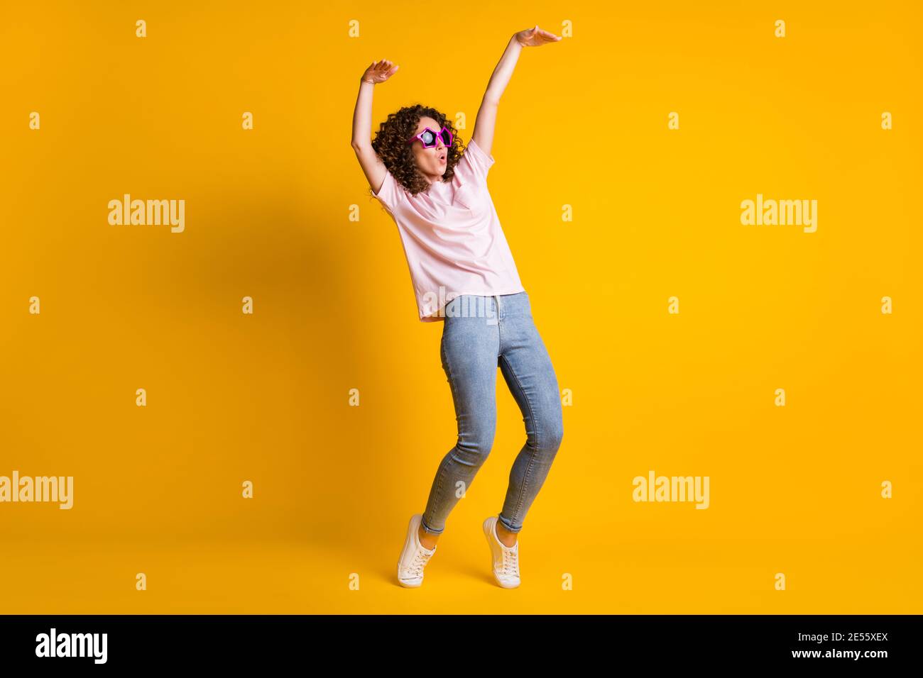 Foto-Portrait Ganzkörperansicht von Mädchen tanzen machen Welle Mit Ganzkörper isoliert auf lebhaft gelbem Hintergrund Stockfoto