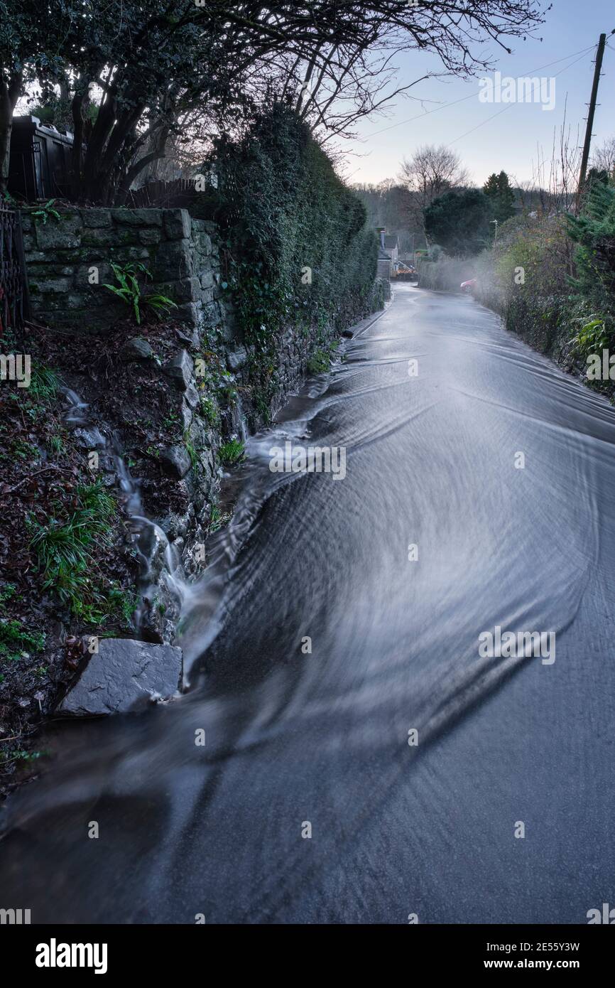 Regenwasser fließt die Trellech Straße hinunter in Tintern. Stockfoto
