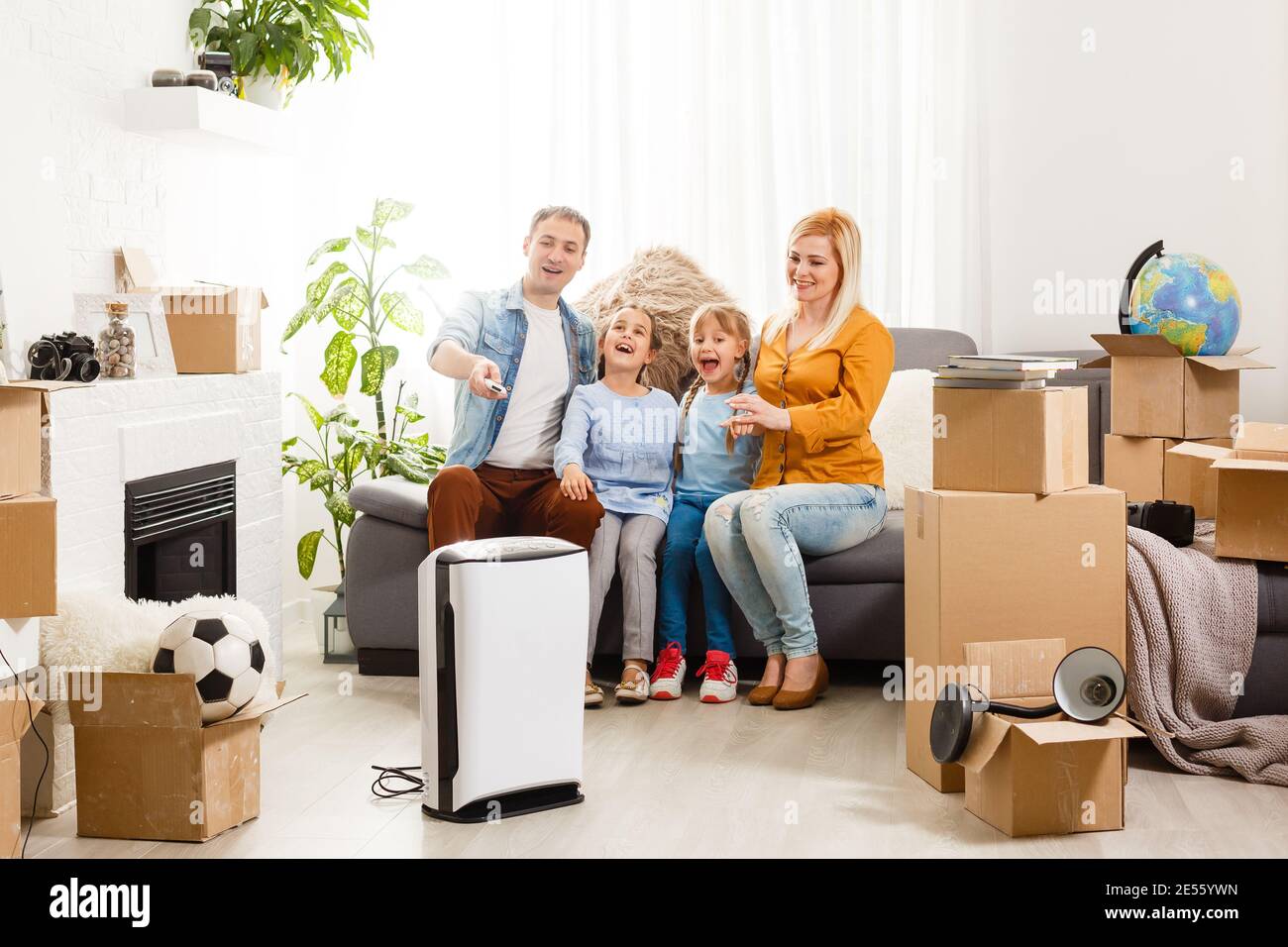 Luftreiniger im Wohnzimmer mit glücklicher Familie Umzug Neue Wohnung Stockfoto