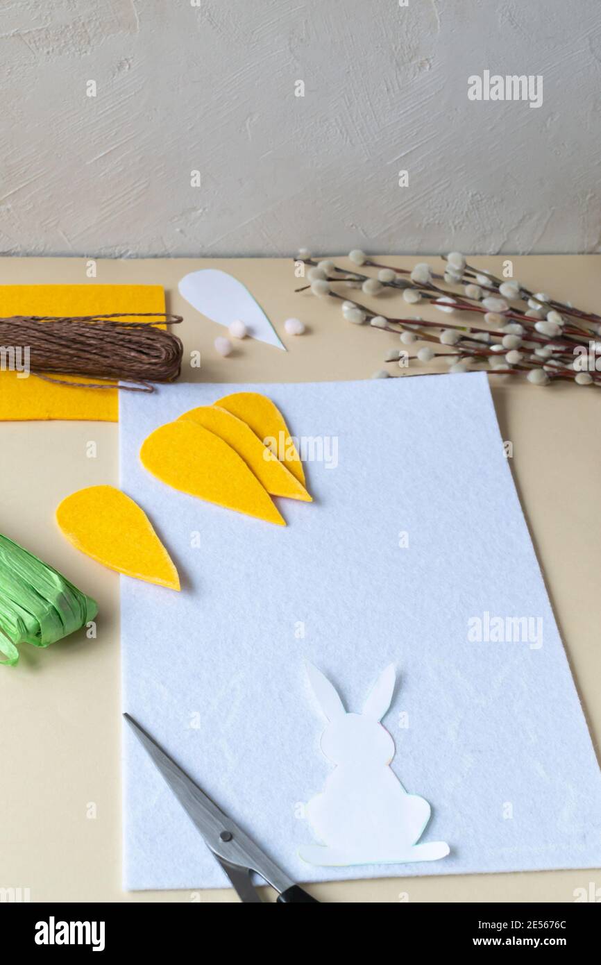 Wie man eine Ostergirlande aus Kaninchen und Karotten mit eigenen Händen aus Filz macht. Schritt-für-Schritt-Anleitung. Schritt 6. Skizzieren Sie die Kaninchen auf Filz. Stockfoto
