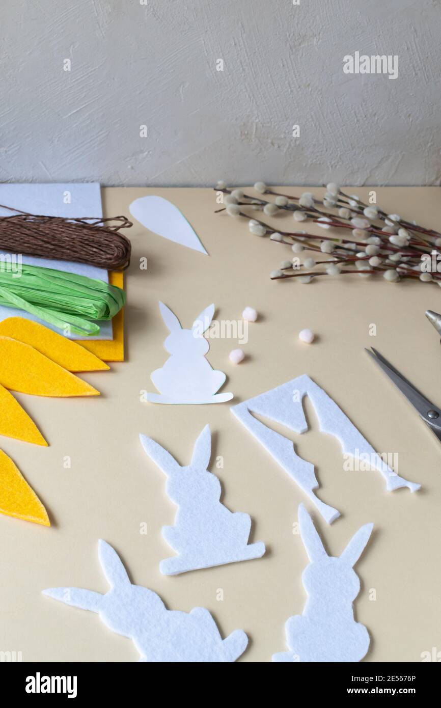 Wie man eine Ostergirlande aus Kaninchen und Karotten mit eigenen Händen aus Filz macht. Schritt-für-Schritt-Anleitung. Schritt 7. Schneiden Sie die Kaninchen aus. Stockfoto