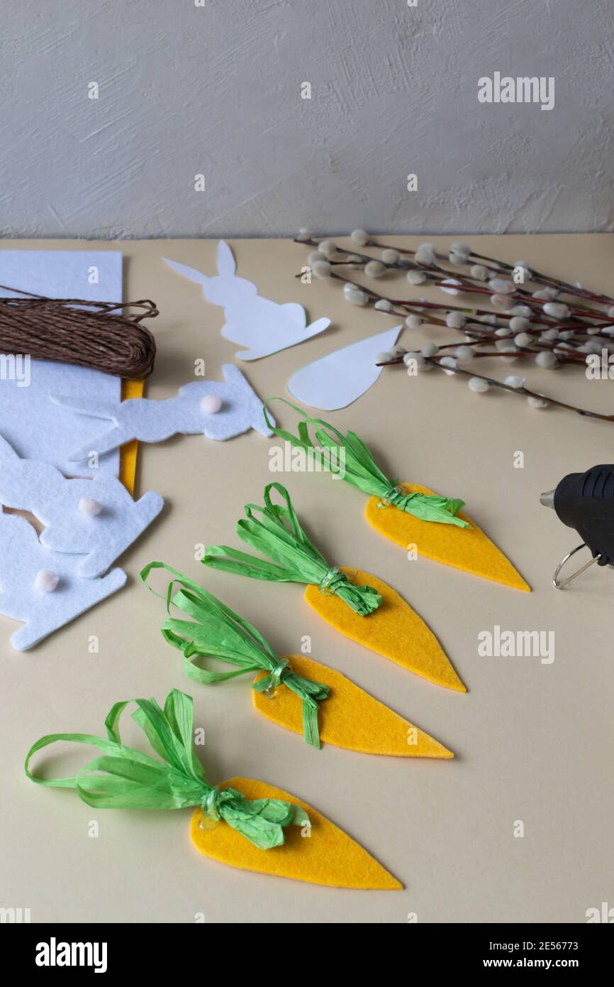 Wie man eine Ostergirlande aus Kaninchen und Karotten mit eigenen Händen aus Filz macht. Schritt-für-Schritt-Anleitung. Schritt 8. Wir machen Karottenspitzen aus Papier Stockfoto