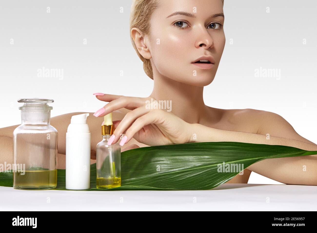 Schöne Frau gilt Organische Kosmetik und Öle für die Schönheit. Spa und Wellness. Modell mit sauberen Haut, glänzendes Haar. Healthcare. Stockfoto