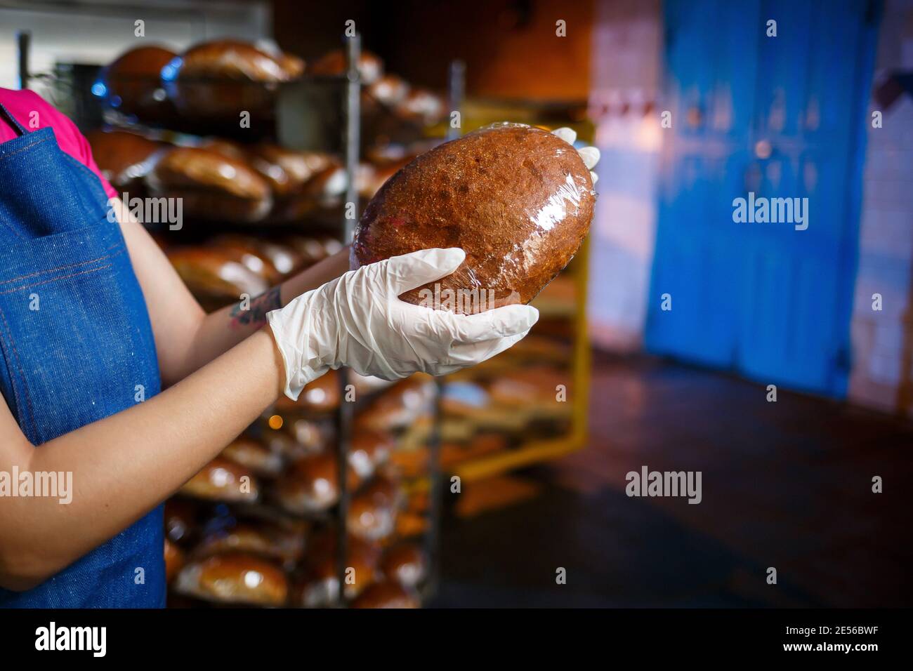 Mädchen Bäcker arbeitet in einer Bäckerei. Frisches knuspriges Brot aus nächster Nähe Stockfoto