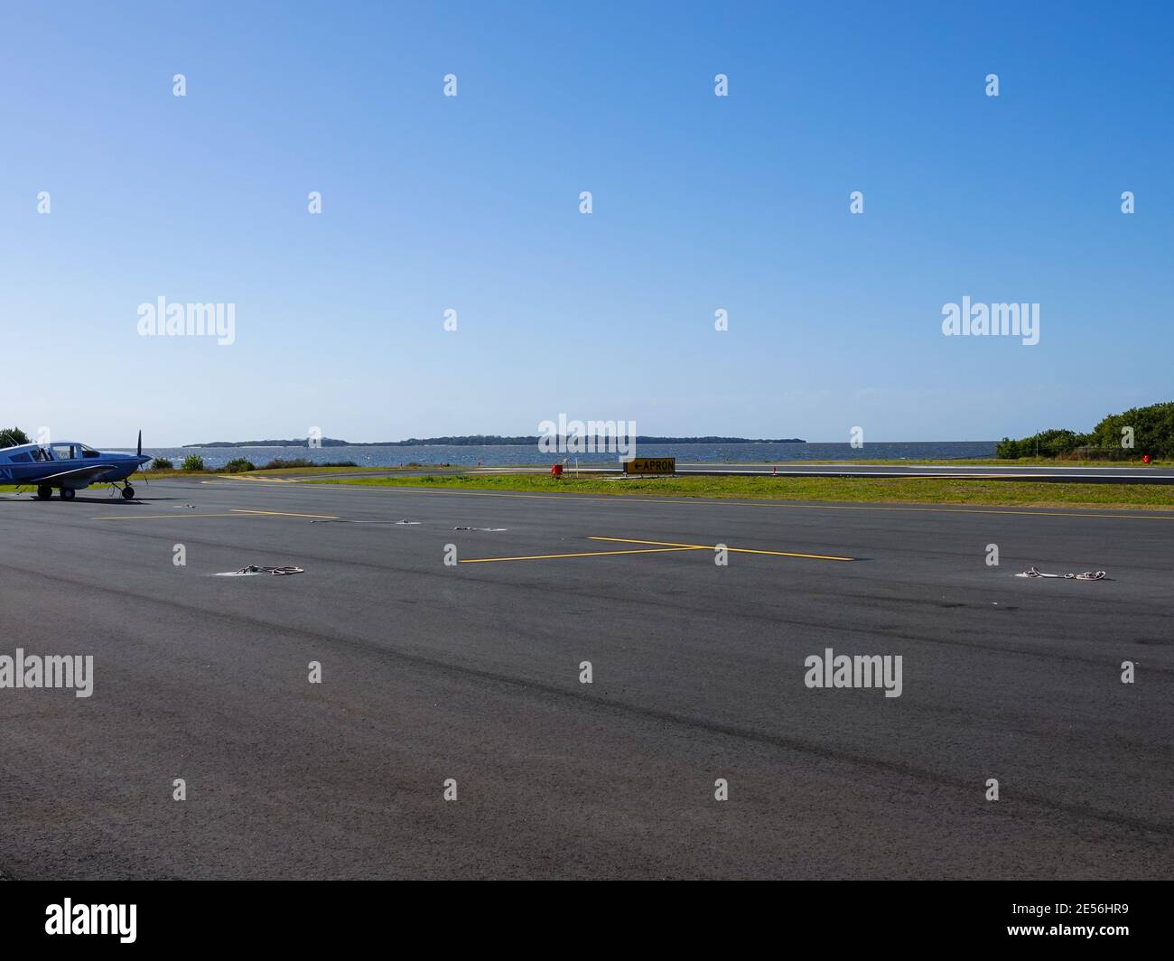 Landebahn am Rande der Insel mit Hintergrundwasser und Kleinflugzeug, George T. Lewis Airport, Cedar, Key, Florida, USA. Stockfoto