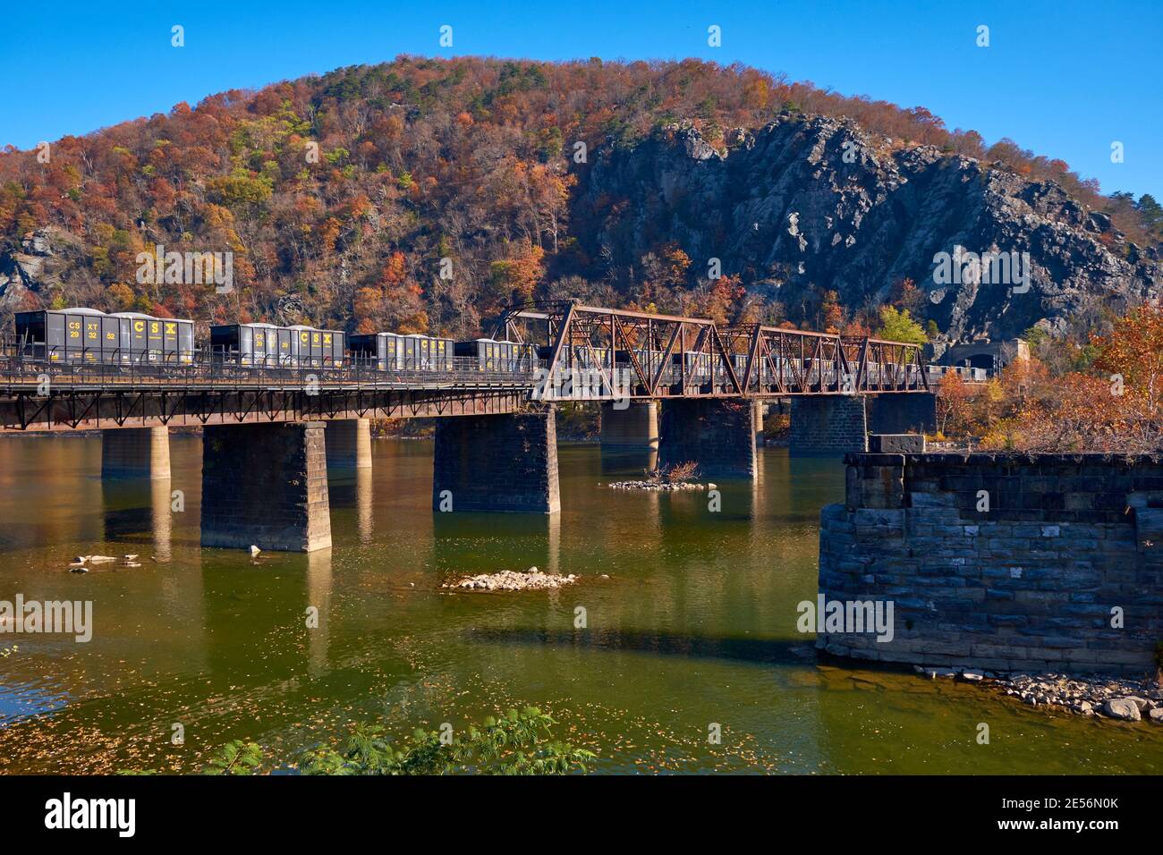 Herbstansicht eines CSX-Zuges mit Trichterwagen über die Eisenbahnbrücke Winchester und Potomac. Bei Harpers Ferry, West Virginia. Stockfoto