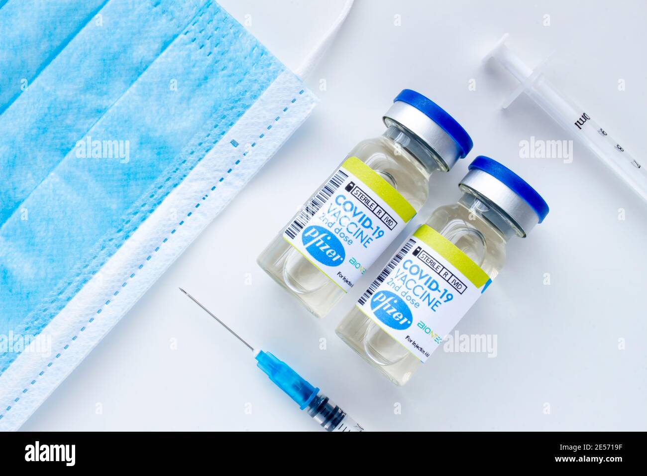 Calgary, Alberta. Kanada. Januar 25 2021. Ein paar Pfizer Covid-19 Impfstoffflaschen mit sterilen Spritzen und einer Gesichtsmaske Stockfoto