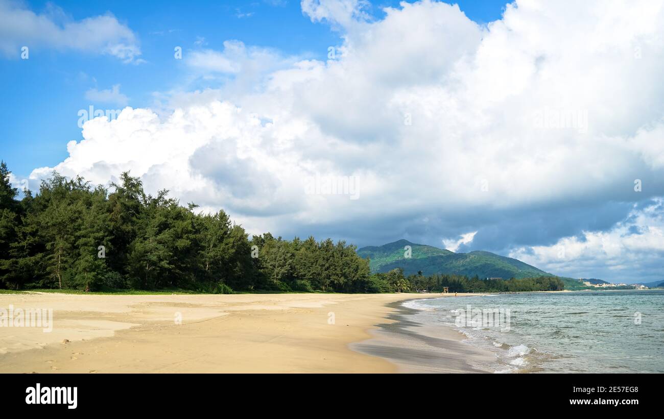 Schöner Strand mit weißen Wolken und Sand auf Hainan Island, sonniges Wetter, Sommerurlaub, flauschige weiße Wolken am Himmel, Reisen in China Stockfoto