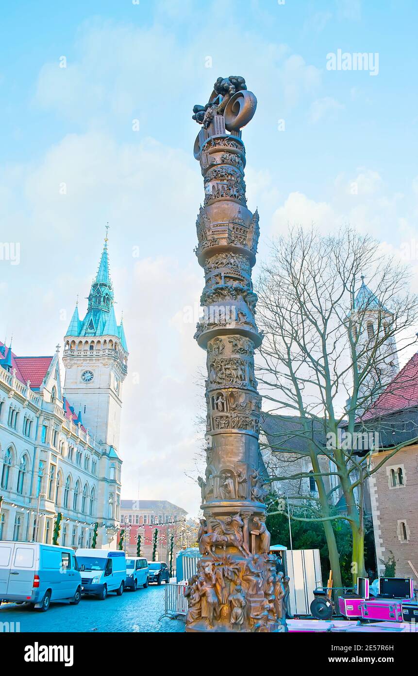 Geschnitzte Säule von 2000 Jahren Christentum, im Domplatz mit szenischem Uhrenturm des Rathauses im Hintergrund, Braunschweig, Deutschland Stockfoto