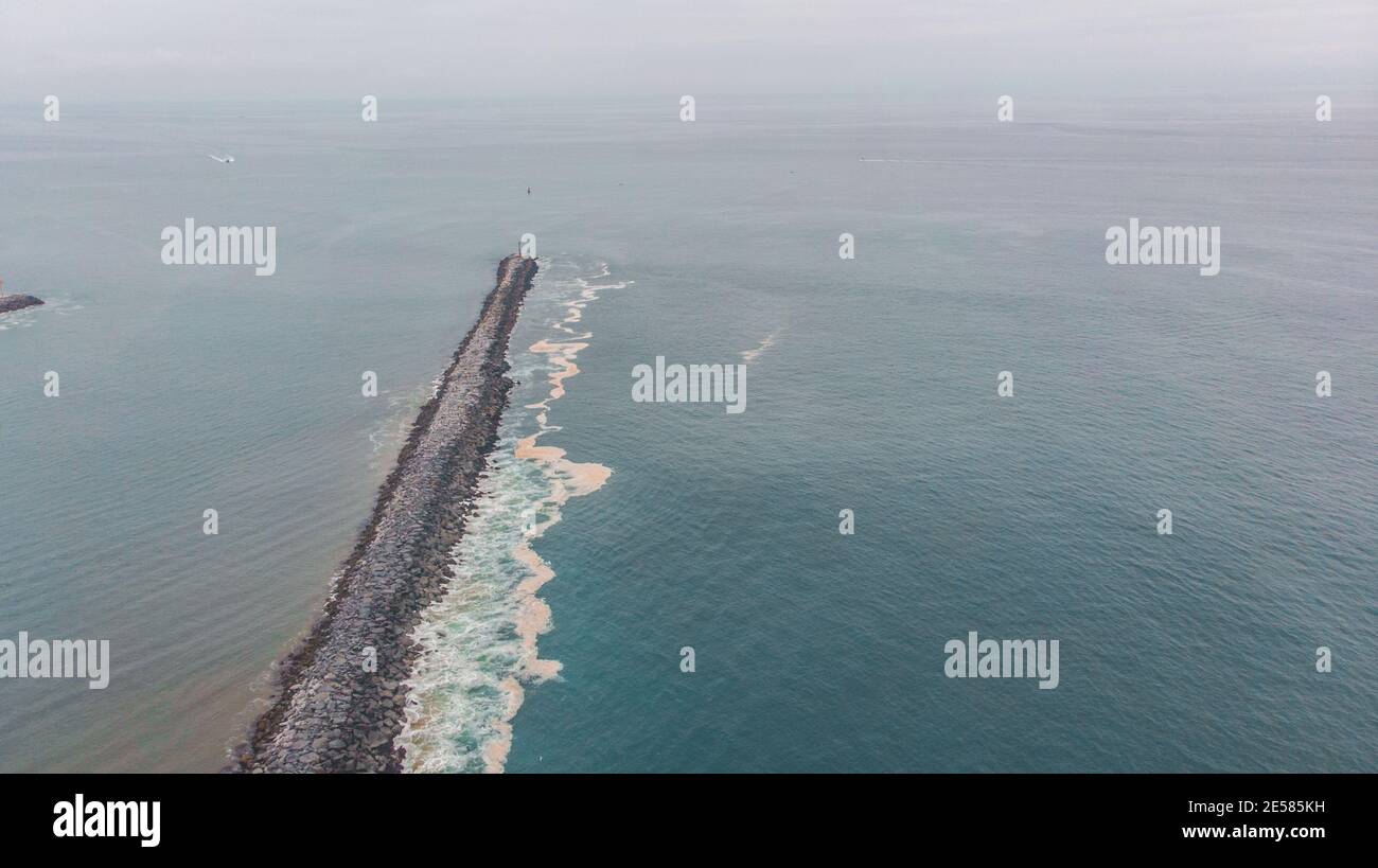 Steinwellenbrecher und Meer an einem regnerischen Tag Stockfoto