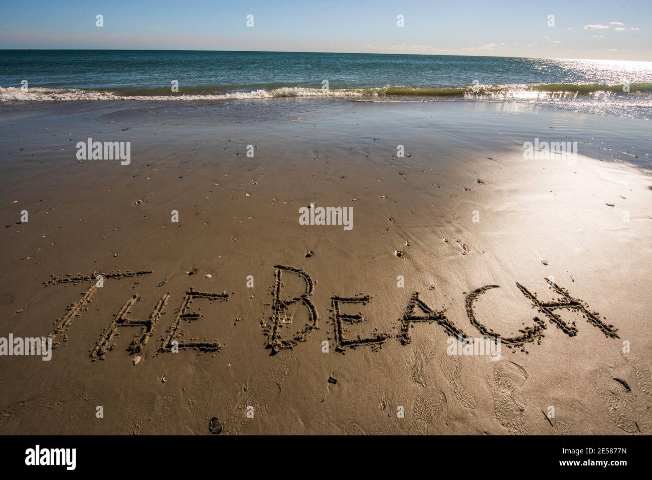 Die Worte DER STRAND in den Sand am Meer geschrieben. Stockfoto