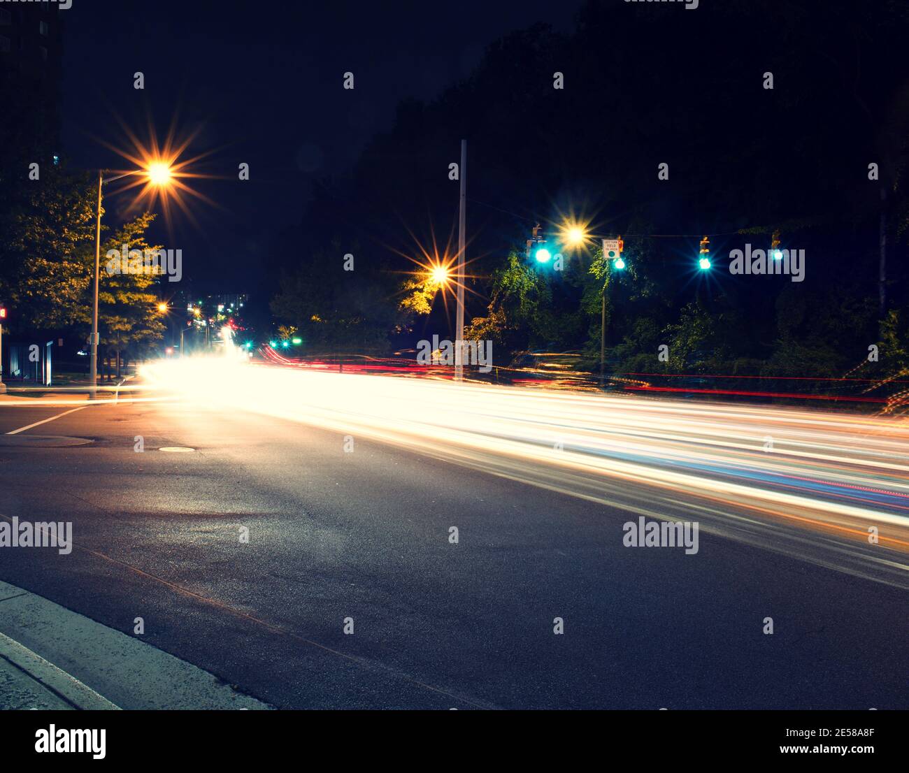Leichte Spuren von Autoverkehr, Scheinwerfern und Bremsleuchten, entlang der Straßen der Stadt in der Nacht. Stockfoto