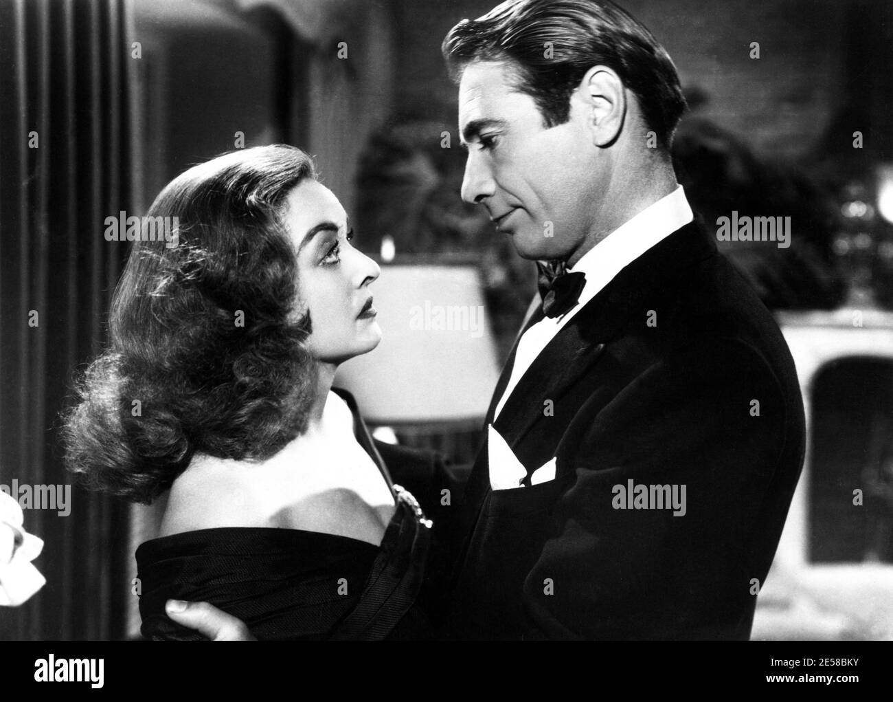 1950 , USA : die Filmschauspielerin BETTE DAVIS ( 1908 - 1989 ) und seine echte Hausband GARY MERRILL in ALLEN ÜBER EVE ( Eva contro Eva ) Von Joseph L. Mankiewicz - KINO - FILM - Attrice - Portrait - ritratto - Embrace - abbraccio - capelli lunghi - lange Haare - Krawatte - papillon - cravatta - Profil - profilo ---- Archivio GBB Stockfoto