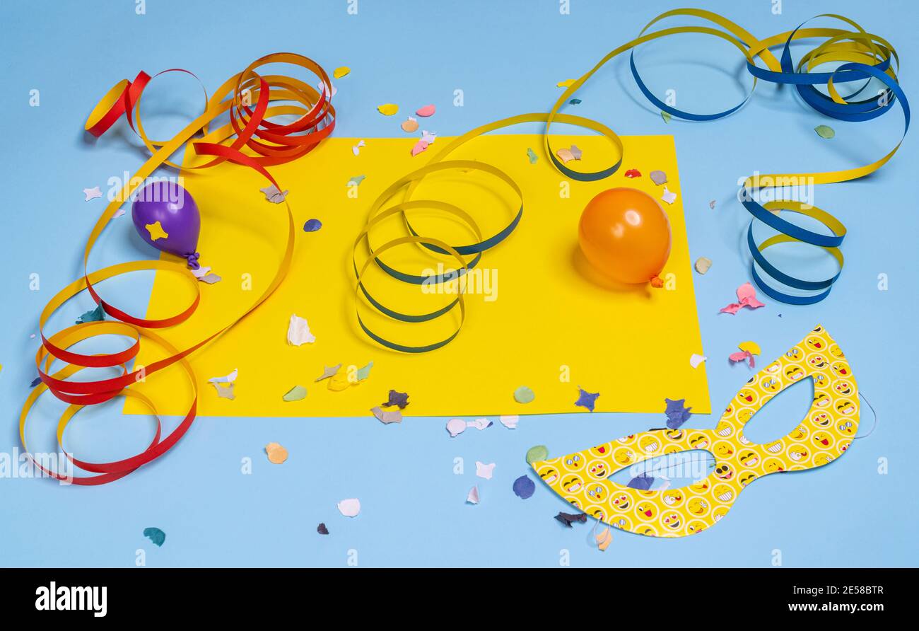 Masken, Konfetti und Streamer auf einem farbenfrohen Karnevalstisch Stockfoto