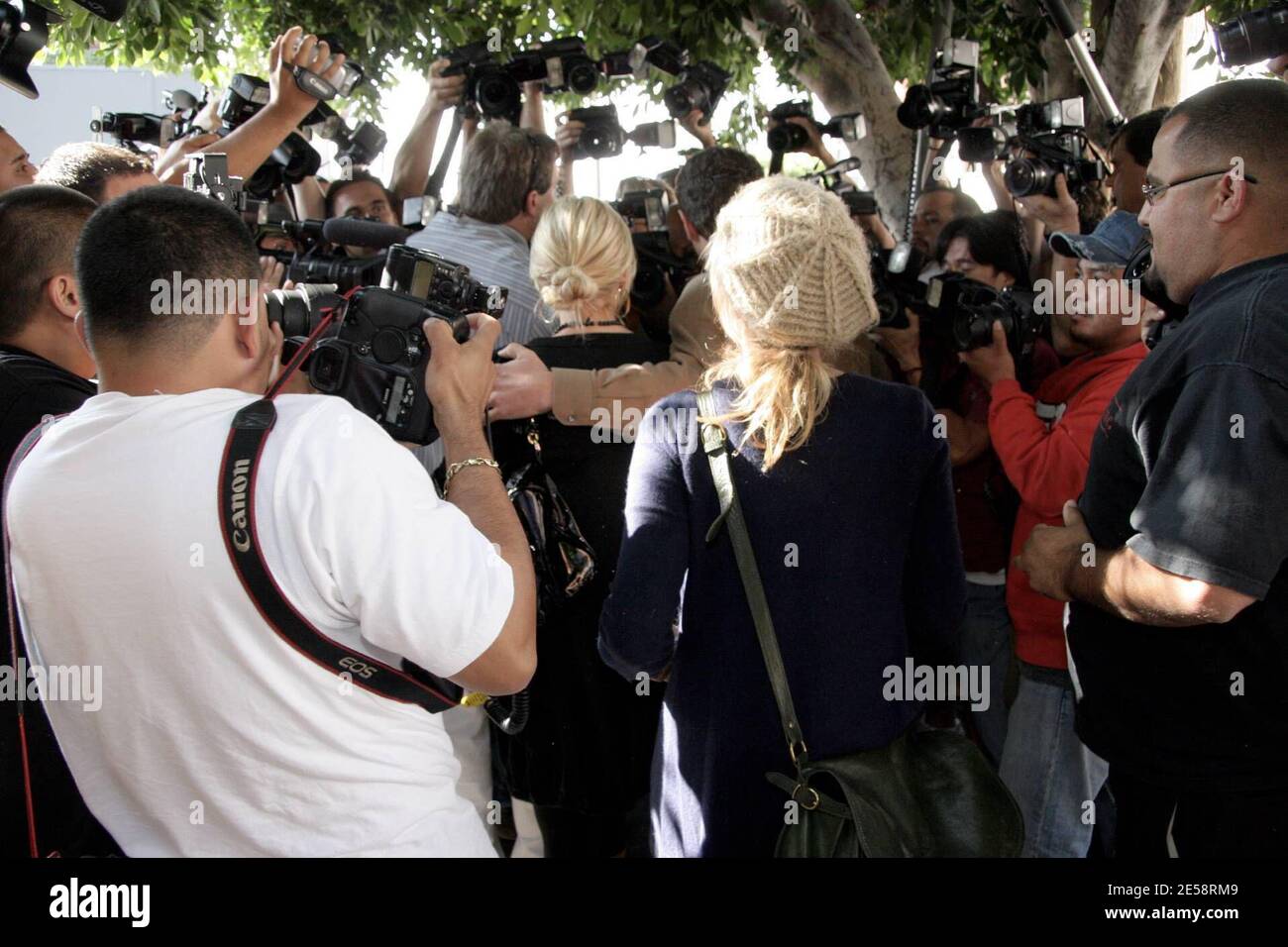 Lindsay Lohan war zwar während der Reha für zwei Monate aus dem Limonenlicht heraus, hat aber ihren Platz in den Reihen der Must-Have-Celebrity-Fotos nicht verloren. Lohan machte sich den Weg durch eine riesige Schar von Fotografen, als sie Orso nach dem Mittagessen heute verlassen. Lindsay schien sich jedoch nicht um die Aufmerksamkeit zu kümmern, da sie zu grinsen schien, als sie sich hinter ihrem Wachmann versteckte. Los Angeles, Kalifornien, 10/17/07. [[rac ral]] Stockfoto