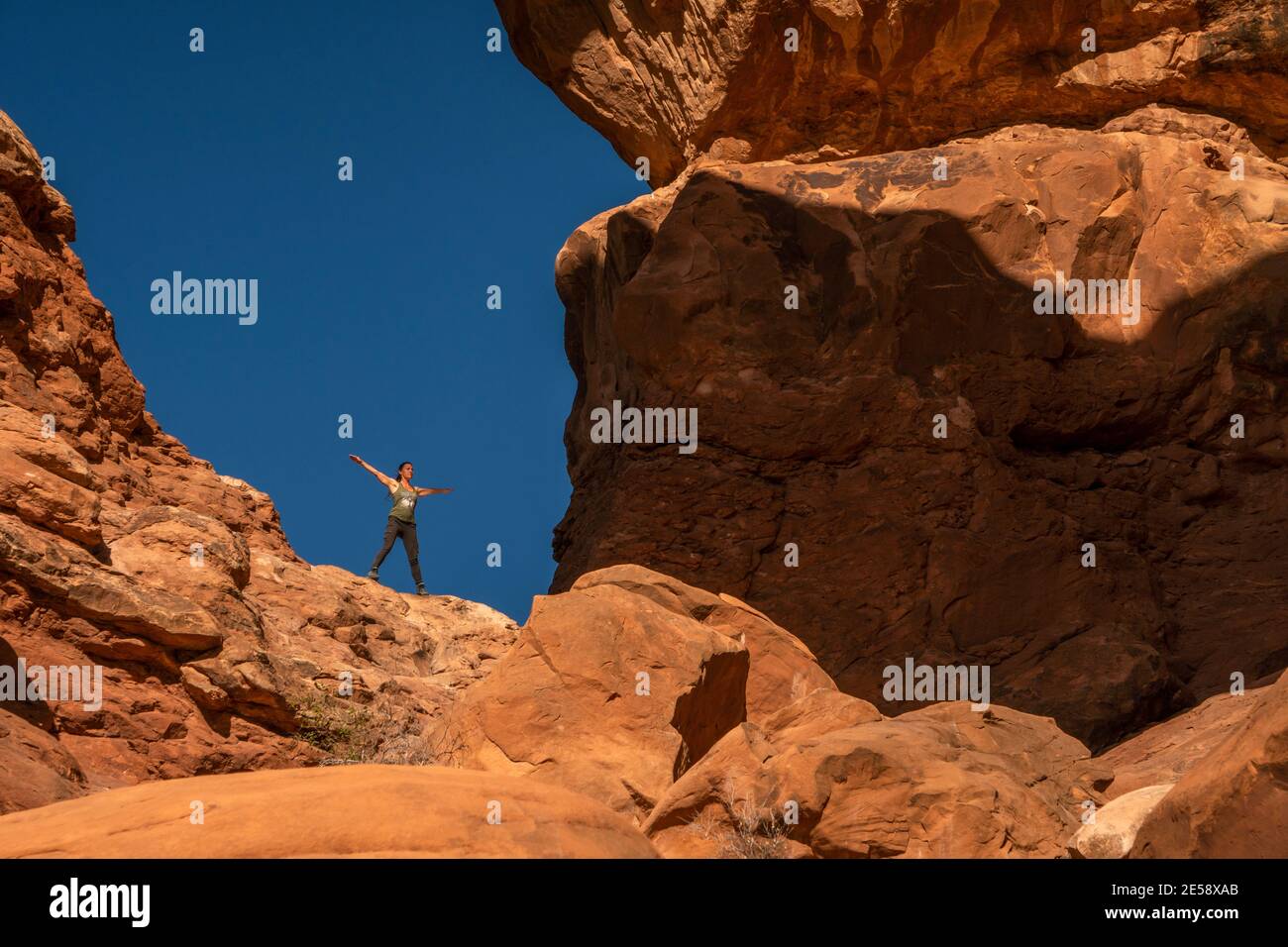 Frau, die in einer der Arches in Arches National posiert Parken Stockfoto