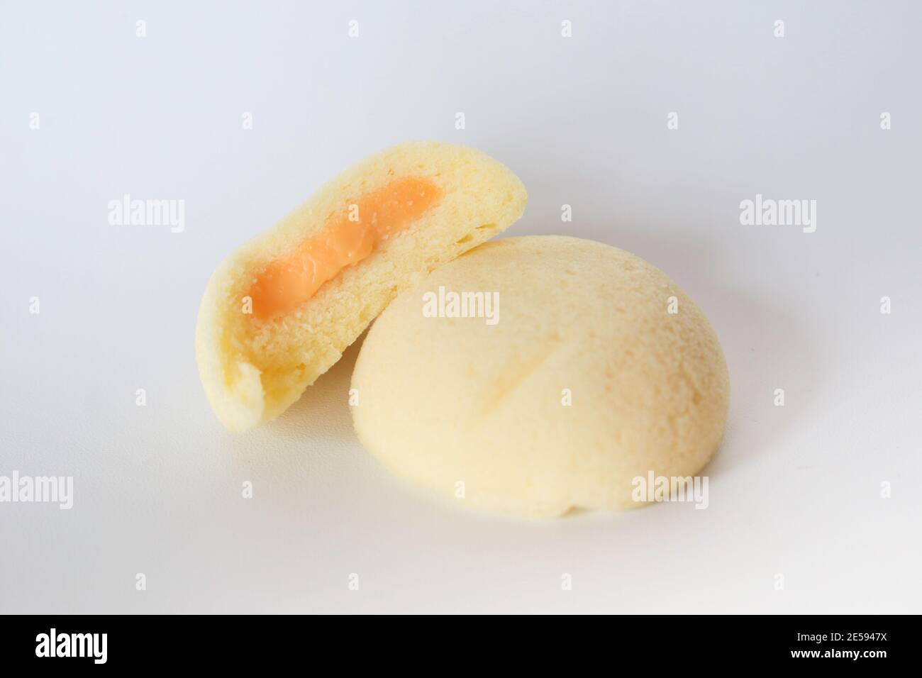 Bakpia Kukus Kuchen oder gedämpfte Bakpia Kuchen mit Käse Geschmack auf Holzplatte isoliert auf weißem Hintergrund. Indonesien-china traditioneller Kuchen aus yogya Stockfoto